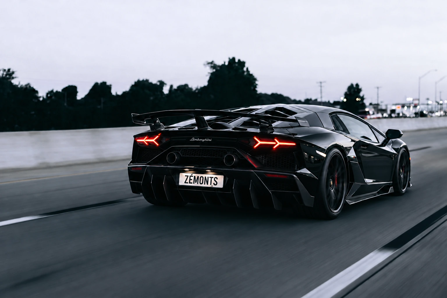 Black Lamborghini Aventador with a ZÉMONTS plate on the road at dusk