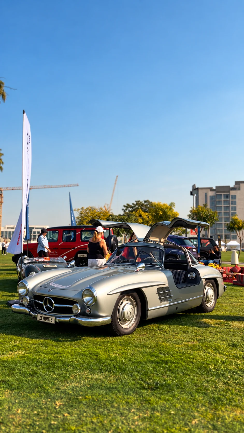 Silver Mercedes 300SL with its gullwing doors raised and a ZÉMONTS plate